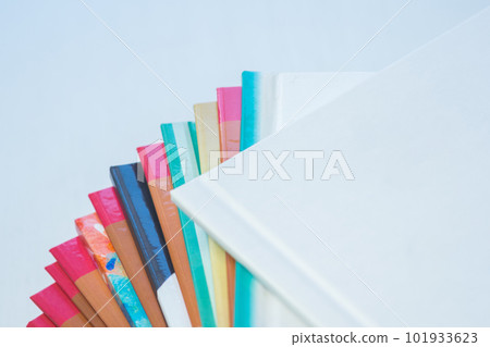 multi-colored spines of photo books close-up, partial blur multi-colored spines of photo books close-up, partial blur 101933623