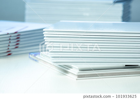stack of freshly printed photobooks on the table close-up 101933625