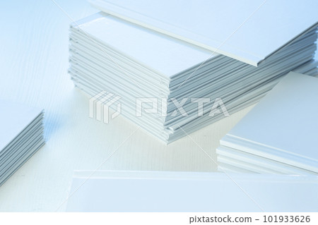 stacks of freshly printed photobooks on the table close-up, clean white cover 101933626