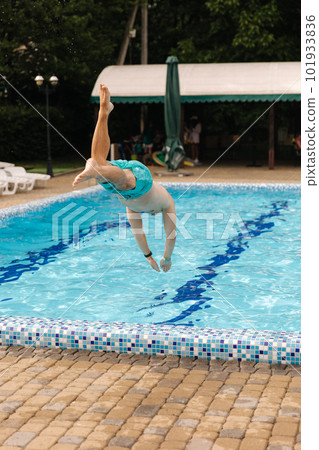 Portrait of handsome man jumping and diving into the swimming pool. Portrait of handsome man jumping and diving into the swimming pool. 101933836