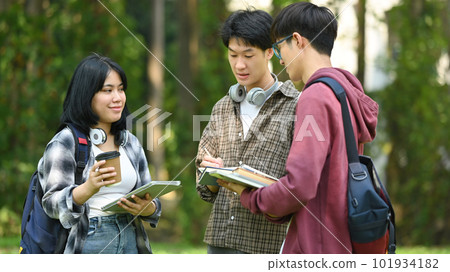 Group of students are talking to each other after classes while walking outdoors in university. Education and youth lifestyle concept Group of students are talking to each other after classes while walking outdoors in university. Education and youth lifestyle concept 101934182