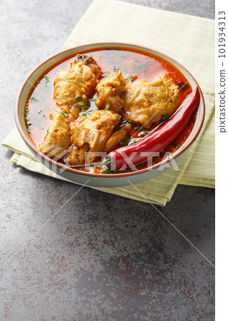 Chicken cooked in spicy gravy made with authentic flavour of malvani closeup on the bowl. Vertical 101934313