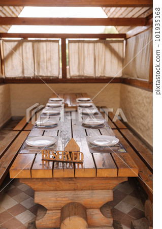 Wooden gazebo with table setting inside. Rustic restaurant in village  101935168