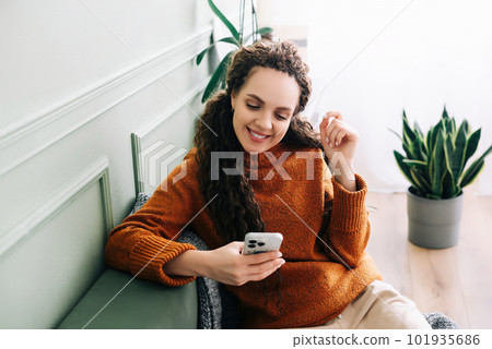 Happy lady browsing e-commerce sites or watching funny videos on a smartphone Enjoying online Happy lady browsing e-commerce sites or watching funny videos on a smartphone Enjoying online 101935686
