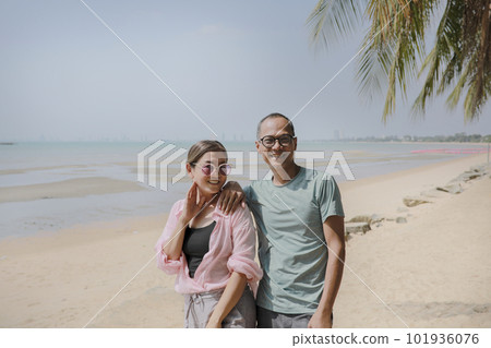 asian couples standing on beautiful sea beach and toothy smiling with happiness face 101936076