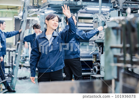 Female worker waving at the factory Female worker waving at the factory 101936078