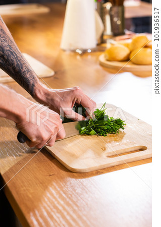 Chef chopping parsley with knife on a wooden board close up 101936517
