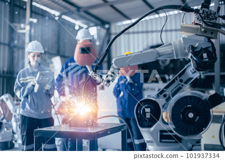Engineer worker team working control operate small robot welding arm in metal workshop Engineer worker team working control operate small robot welding arm in metal workshop 101937334