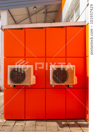 Two air compressors installation on orange wall outside. Two air compressors installation on orange wall outside. 101937429