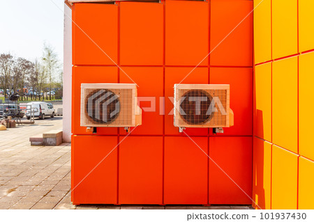 Two air compressors installation on orange wall outside. Two air compressors installation on orange wall outside. 101937430