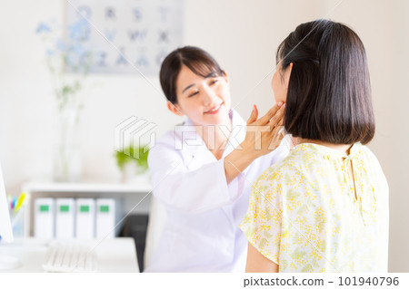 doctor examining a young woman 101940796