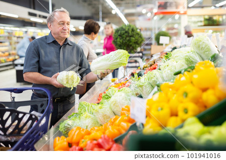 elderly man chooses china cabbage in vegetable and fruit department elderly man chooses china cabbage in vegetable and fruit department 101941016