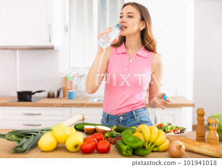 Attractive woman drinking water in the kitchen before breakfast Attractive woman drinking water in the kitchen before breakfast 101941018