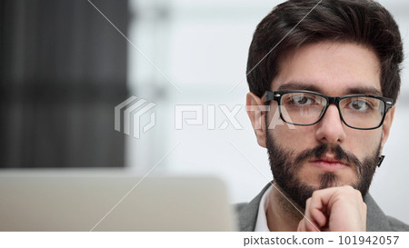Businessman using a laptop while working late in his office 101942057