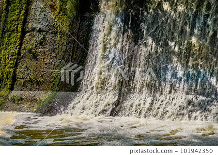 Pleasant freshness.River dam with clear flowing water on a warm sunny day Pleasant freshness.River dam with clear flowing water on a warm sunny day 101942350