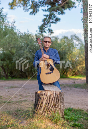 A man with a classical or Spanish guitar in nature. Concepts of music and recreation. 101943167