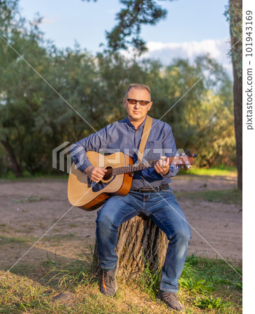 A man with a classical or Spanish guitar in nature. Concepts of music and recreation. 101943169