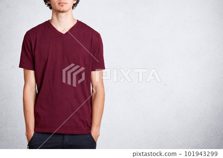 Cropped shot of unrecognizable male keeps hands in pocket, wears casual t shirt with blank copy space for your design or advertisement, stands against white background. People and clothing concept Cropped shot of unrecognizable male keeps hands in pocket, wears casual t shirt with blank copy space for your design or advertisement, stands against white background. People and clothing concept 101943299