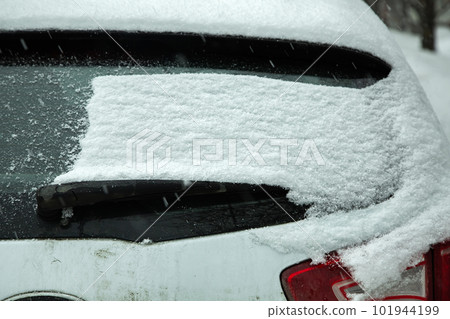 rear car window covered with a layer of snow blocked windshield wiper with snowdrift dirty rear tailgate, nobody. rear car window covered with a layer of snow blocked windshield wiper with snowdrift dirty rear tailgate, nobody. 101944199