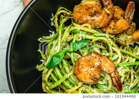 Pasta spaghetti zucchini basil pesto sauce and grilled shrimp, Vegetarian vegetable pasta, Food recipe background. Close up 101944486
