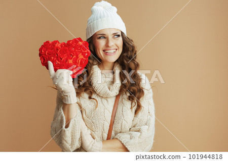 smiling stylish woman on beige background with red heart 101944818