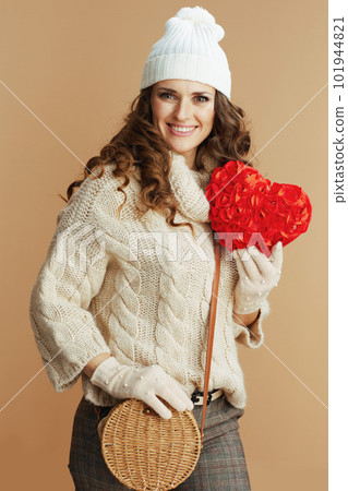 smiling stylish woman on beige background with red heart 101944821