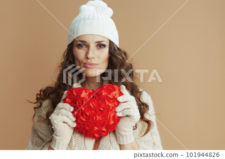Portrait of stylish woman in beige sweater, mittens and hat 101944826