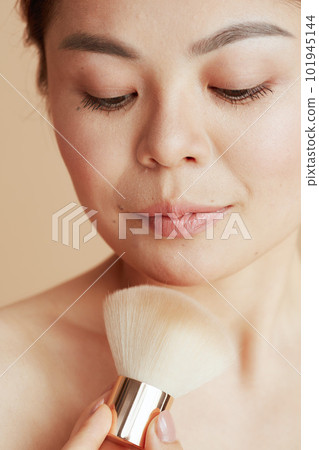 modern asian woman with makeup brush 101945144