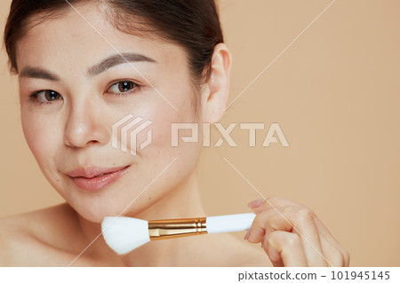 Portrait of modern woman with makeup brush Portrait of modern woman with makeup brush 101945145