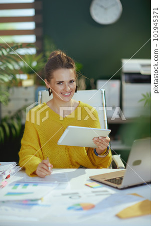 happy trendy business owner woman in sweater in green office happy trendy business owner woman in sweater in green office 101945371