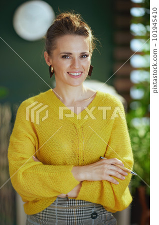 smiling trendy business owner woman standing in green office smiling trendy business owner woman standing in green office 101945410