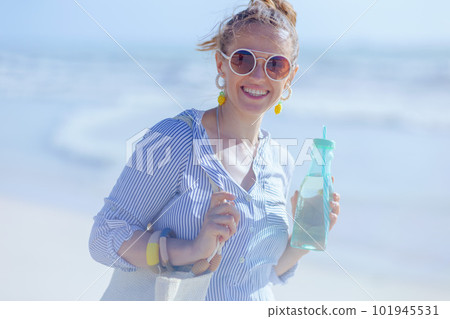Portrait of smiling modern 40 years old woman at beach Portrait of smiling modern 40 years old woman at beach 101945531