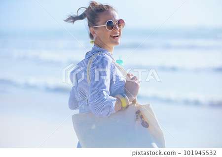 smiling modern female with white straw bag at beach smiling modern female with white straw bag at beach 101945532