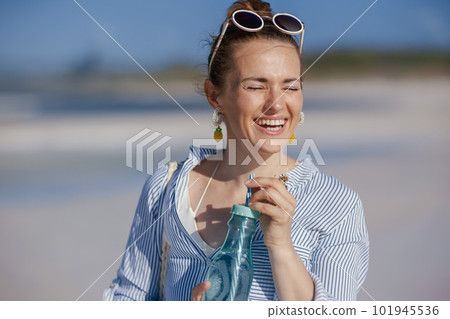 smiling elegant woman with drink at beach 101945536
