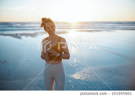smiling fitness woman jogger at beach in evening smiling fitness woman jogger at beach in evening 101945601