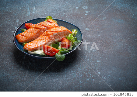 Grilled fish salmon steak with vegetables salad on ceramic plate on rustic stone background angle view, balanced diet, healthy nutrition salad meal with salmon and veggies, space for text Grilled fish salmon steak with vegetables salad on ceramic plate on rustic stone background angle view, balanced diet, healthy nutrition salad meal with salmon and veggies, space for text 101945933