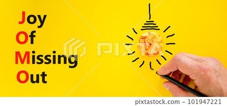 JOMO joy of missing out symbol. Concept words JOMO joy of missing out on beautiful yellow background. Businessman hand. Light bulb icon. Business JOMO joy of missing out concept. Copy space. JOMO joy of missing out symbol. Concept words JOMO joy of missing out on beautiful yellow background. Businessman hand. Light bulb icon. Business JOMO joy of missing out concept. Copy space. 101947221
