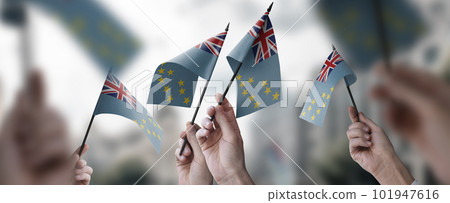 A group of people holding small flags of the Tuvalu in their hands 101947616