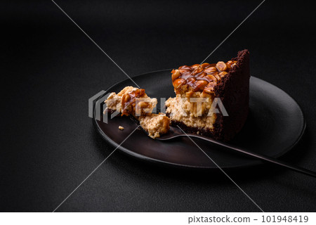 Delicious fresh cheesecake cake or snickers with cream and nuts Delicious fresh cheesecake cake or snickers with cream and nuts 101948419