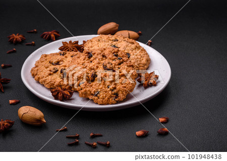 Delicious baked oatmeal raisin cookies on a dark concrete background 101948438