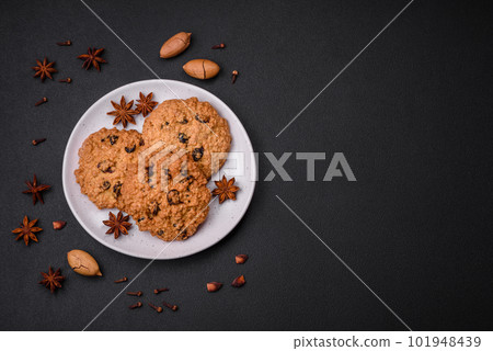 Delicious baked oatmeal raisin cookies on a dark concrete background 101948439