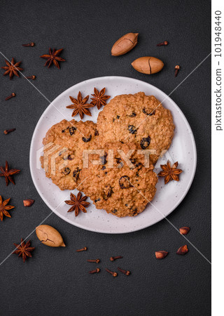 Delicious baked oatmeal raisin cookies on a dark concrete background 101948440