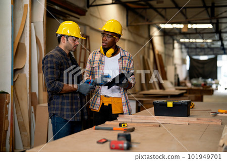 African American and Caucasian carpenter man discuss together about wood work using tablet 101949701