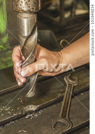 girl holding a huge drill at the factory girl holding a huge drill at the factory 101949834