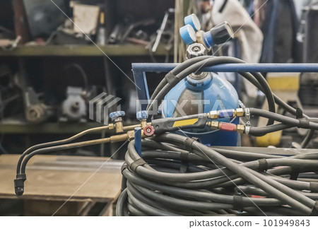 Gas cylinder, hose and blowtorch at the factory 101949843