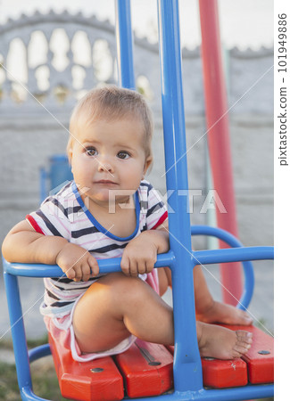 Blonde baby on a swing at sunset Blonde baby on a swing at sunset 101949886