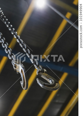 metal hook hanging on a chain in a factory focus on the hook metal hook hanging on a chain in a factory focus on the hook 101949904