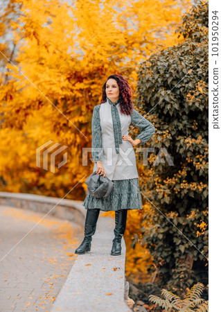 A woman walks outdoors in autumn, enjoys the autumn weather. A woman walks outdoors in autumn, enjoys the autumn weather. 101950294