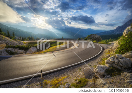 Mountain road at colorful sunset in summer. Curved roadway 101950696