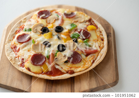 Milanese-style pizza with a thin crust Milanese-style pizza with a thin crust 101951062
